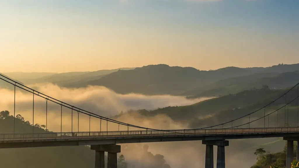 The Engineering Marvel suspension bridge in misty hills at sunrise